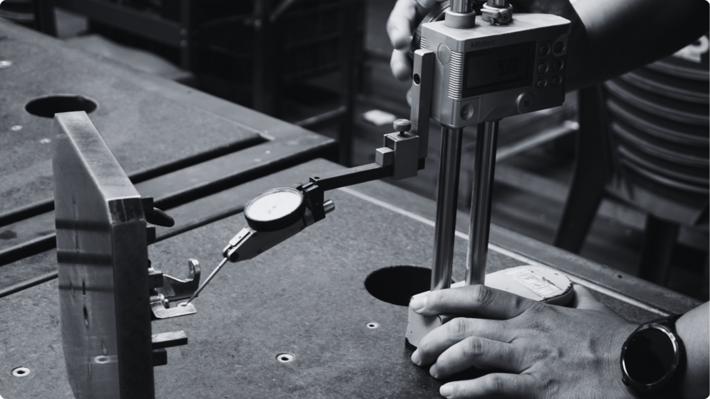 Operator checking a part with a dial gauge and height gauge in the Inspection step