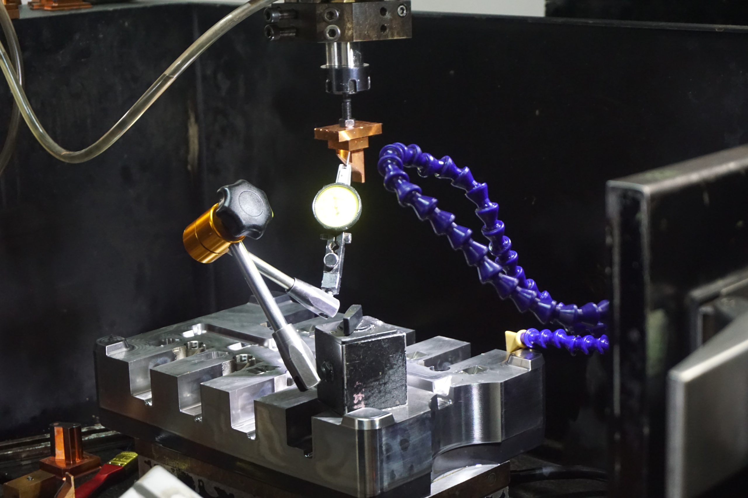 Die casting mould block clamped in the machine with a dial indicator and copper electrode above it
